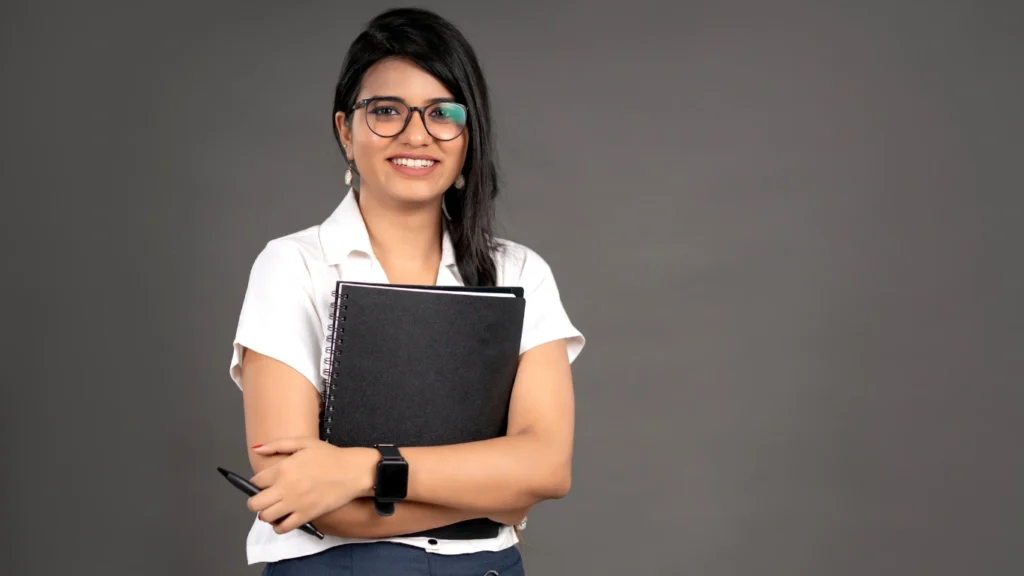 Adult professional holding a notebook and smiling