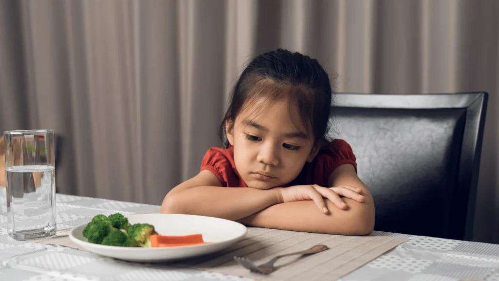 Child refusing to eat unfamiliar foods at the dining table