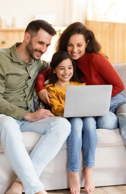 Happy family attending an online session on a laptop